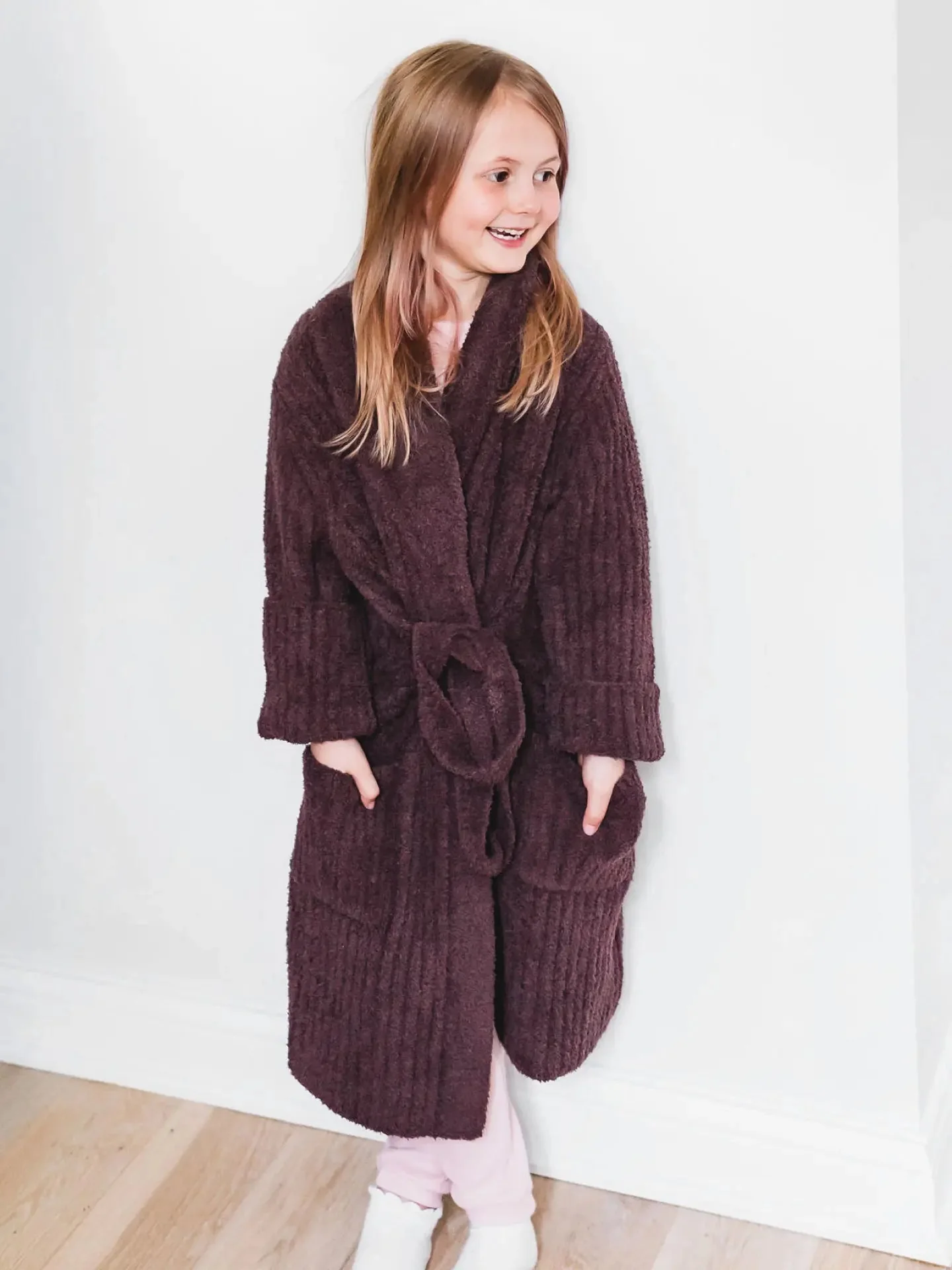 Child wearing a deep brown Little Giraffe robe against a light studio background